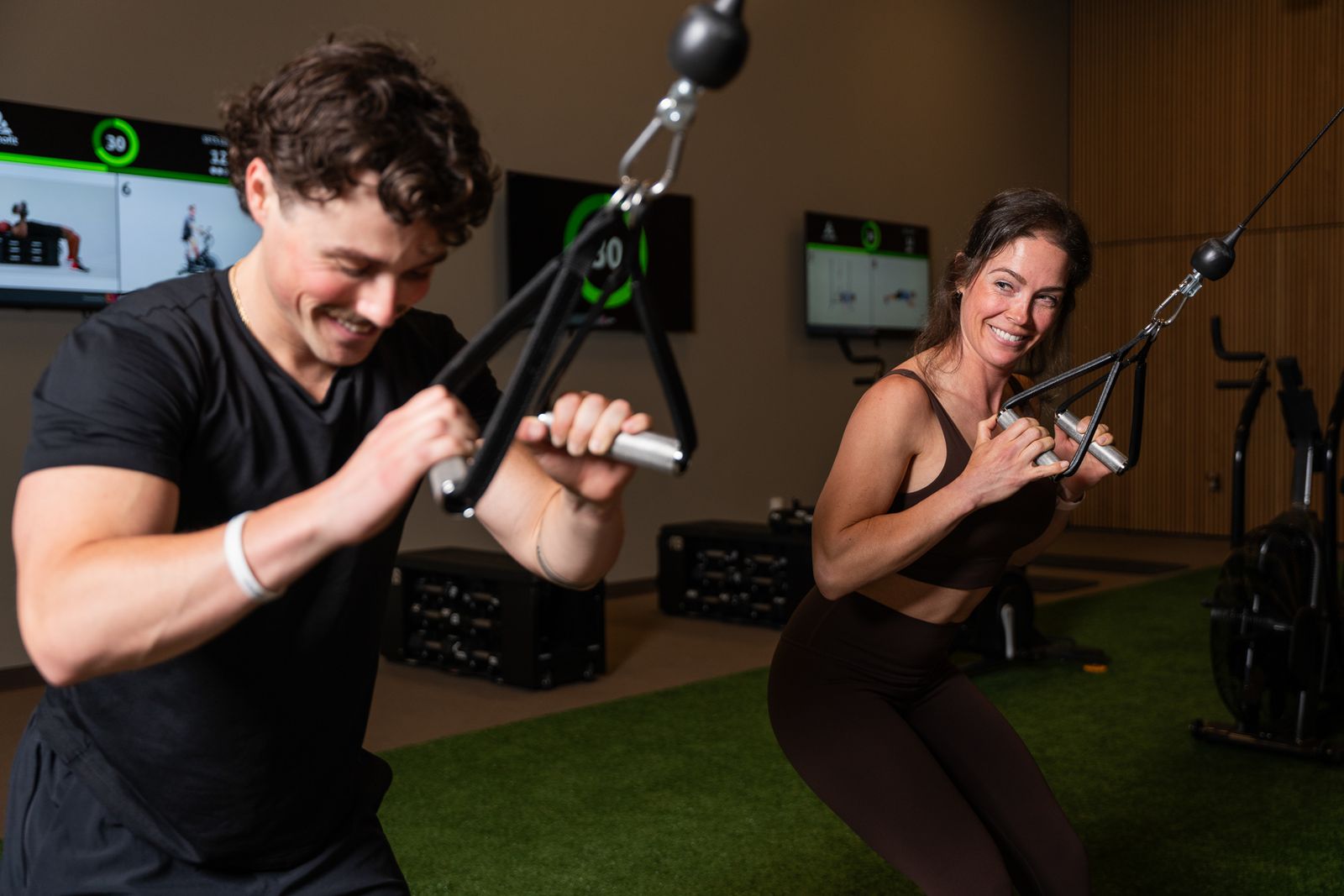 Coach-led strength training with digital workout displays in the Komplex Studio at somofit