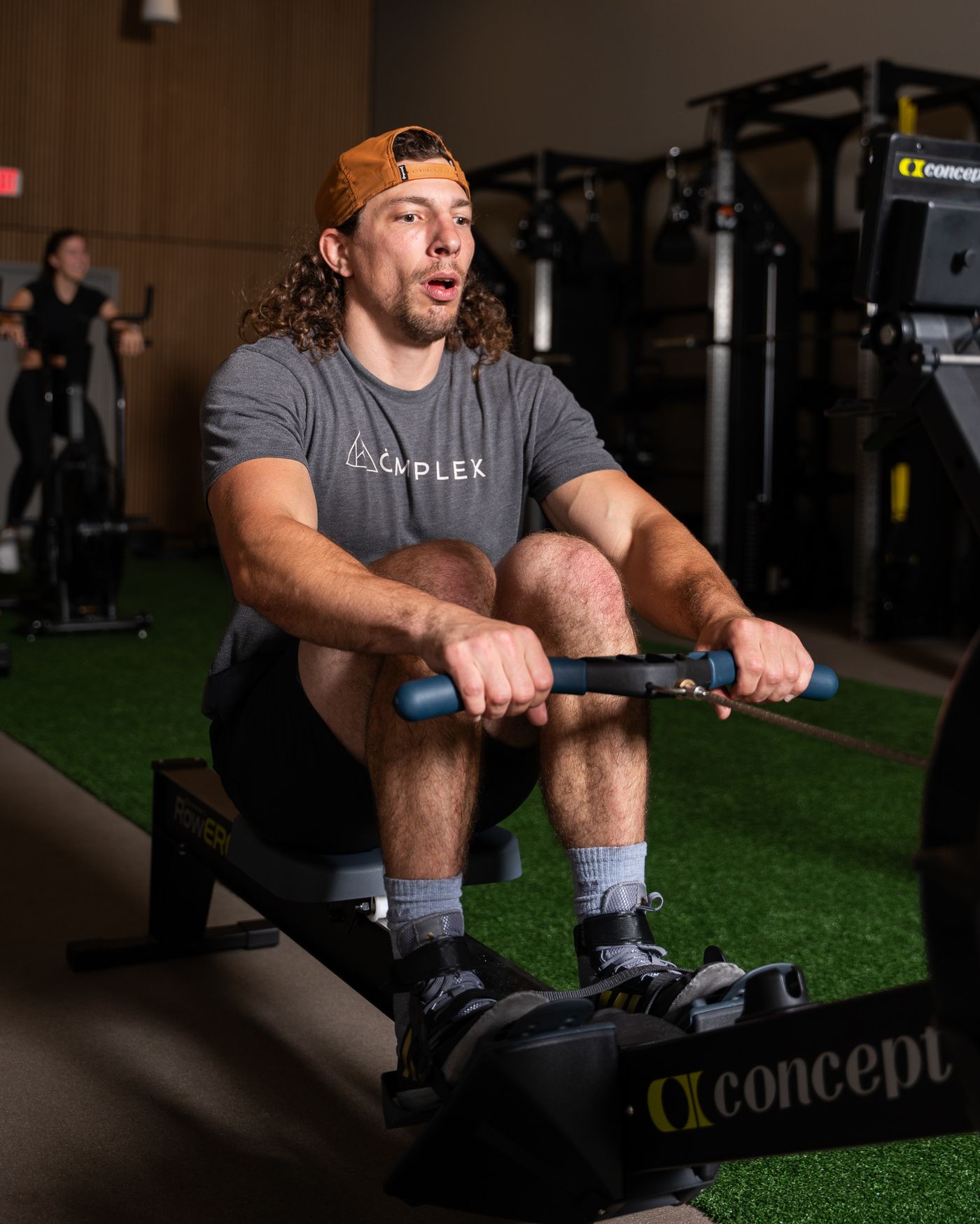 Member rowing on a Concept2 erg during a coach-led Komplex Studio class at somofit