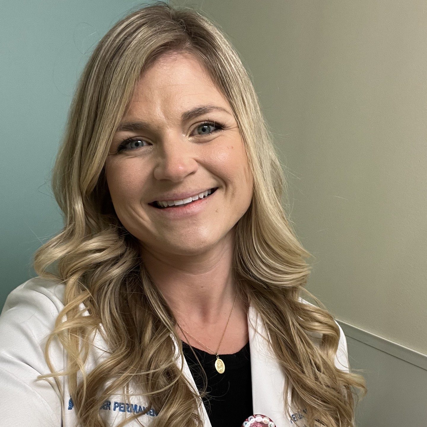 Rachel D. smiling in her physical therapist white coat
